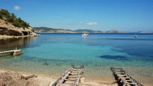Casetas de pescadores en Cala Llentrisca junto al mar cristalino del sur de Ibiza.