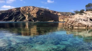 Costa de Es Cubells en Ibiza con acantilados y mar en calma de color azul profundo.