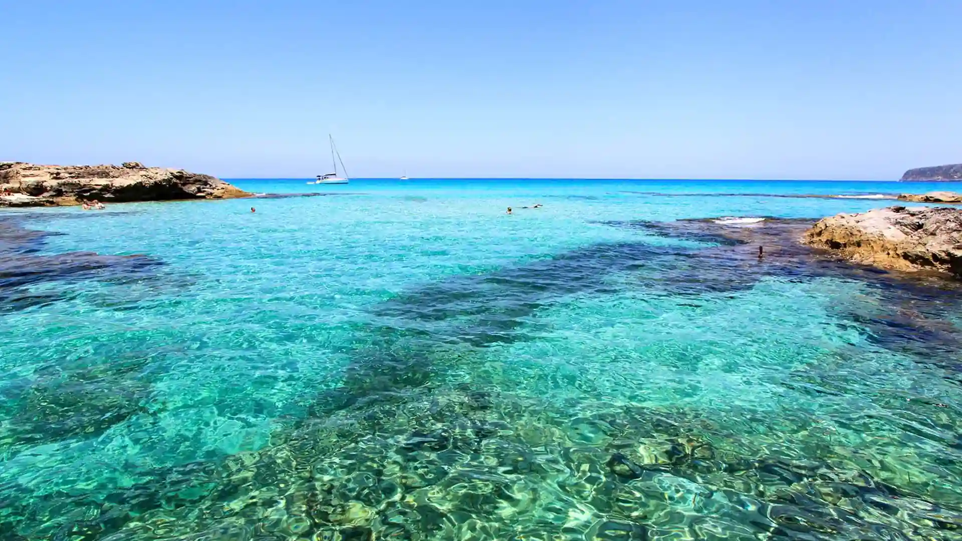 Aguas turquesas en Formentera durante una ruta en barco por la zona de Es Caló, ideal para fondeo y navegación tranquila